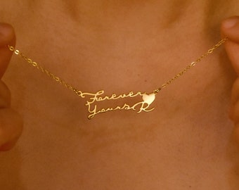 May include: Gold necklace with a delicate chain and a pendant that says "Forever Yours" with a heart symbol.