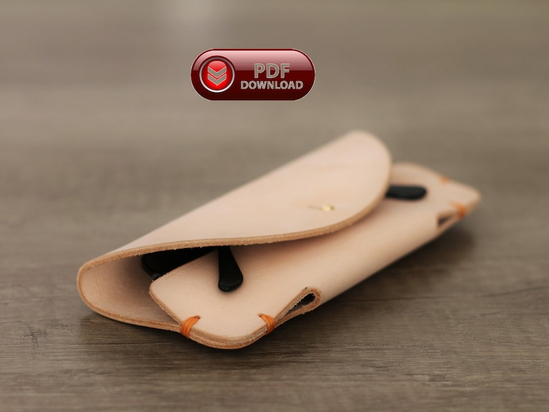 Puede incluir: Un estuche de gafas de cuero de color beige claro con gafas de sol negras en el interior. El estuche est&aacute; doblado y asegurado con un peque&ntilde;o bot&oacute;n de lat&oacute;n. Los bordes est&aacute;n cosidos con hilo naranja. El texto "PDF DOWNLOAD" es visible en la esquina superior izquierda.