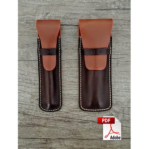 May include: Two leather pen cases. The cases are brown with a lighter brown flap and a black strap with "D-K" embossed. The cases are stitched with white thread. The case on the right is slightly larger than the one on the left.