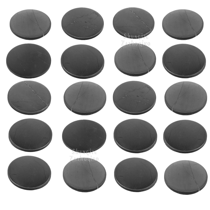 May include: A collection of sixteen dark gray, circular stones with a slightly textured surface. Some stones have subtle veining patterns. The stones are arranged in a grid pattern against a white background.