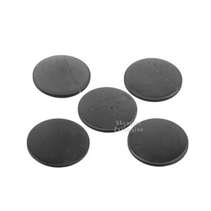 May include: Five round, dark gray coasters with subtle veining. The coasters are made of a solid material and have a smooth surface. The coasters are arranged in a scattered pattern. The coasters are suitable for use with glasses and mugs.