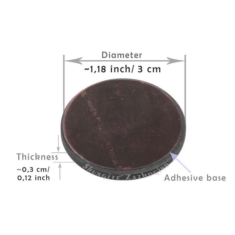 May include: A round, dark brown shungite stone with a diameter of approximately 1.18 inches (3 cm) and a thickness of about 0.12 inches (0.3 cm). The stone has an adhesive base and the text "SHUNGITE ZAZHOGINO" is visible.