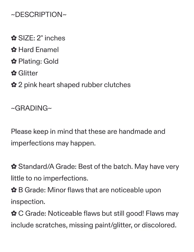 May include: Text description of a product, including size, materials, and grading. The product is 2 inches in size, made of hard enamel with gold plating and glitter. It includes two pink heart-shaped rubber clutches. Grading information is also provided.