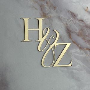 May include: Gold-colored metal initials "H & Z" with a decorative script font for the "Z".
