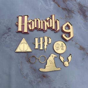 May include: A selection of gold-coloured Harry Potter-themed cutouts, including the name "Hannah" with the number "9", a lightning bolt, glasses, a sorting hat, a golden snitch, and the HP logo.