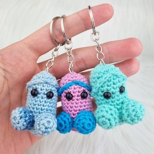 May include: Three crocheted octopus keychains with silver key rings. The octopus are blue, pink, and teal.