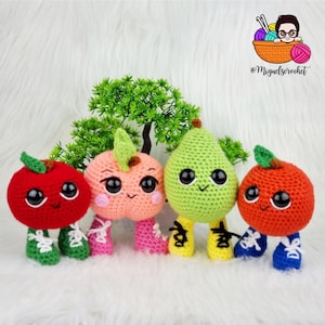 May include: Four crocheted fruit plushies with smiling faces and big eyes. The plushies are an apple, peach, pear, and orange. Each plush has small legs and is wearing shoes.