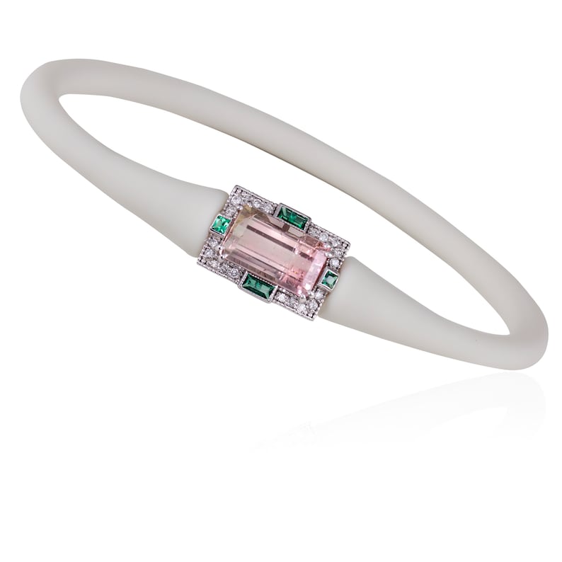 May include: A white silicone bracelet featuring a pink and green gemstone set in a silver frame. The gemstone is surrounded by smaller diamonds.