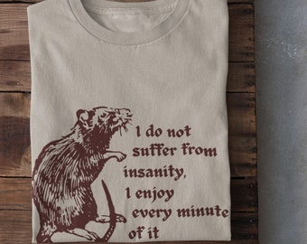May include: A beige t-shirt with a brown rat illustration and the text "I do not suffer from insanity, I enjoy every minute of it".