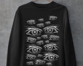 May include: Black sweatshirt with a white print of multiple eyes. The eyes are arranged in a pattern on the front of the sweatshirt.