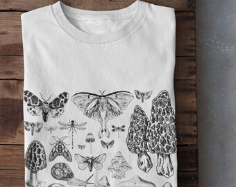 May include: White t-shirt with a black and white illustration of mushrooms, butterflies, and other insects.