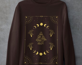 May include: A brown sweatshirt with a gold graphic design featuring mushrooms and moons in a geometric pattern.