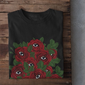 May include: Black t-shirt with a graphic of red roses with eyes on them.