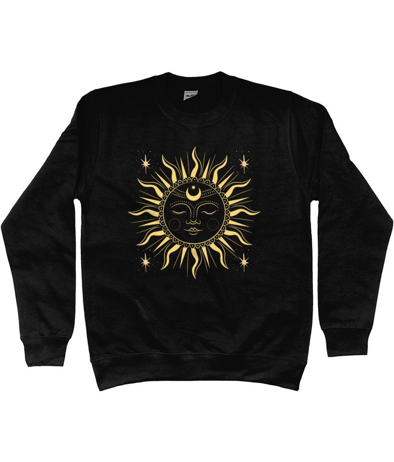 May include: Black sweatshirt with a gold sun and moon design. The sun has a face and is surrounded by stars.