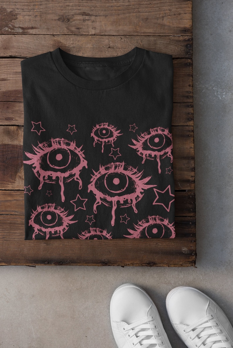 May include: Black t-shirt with a pink and black eye and star pattern.
