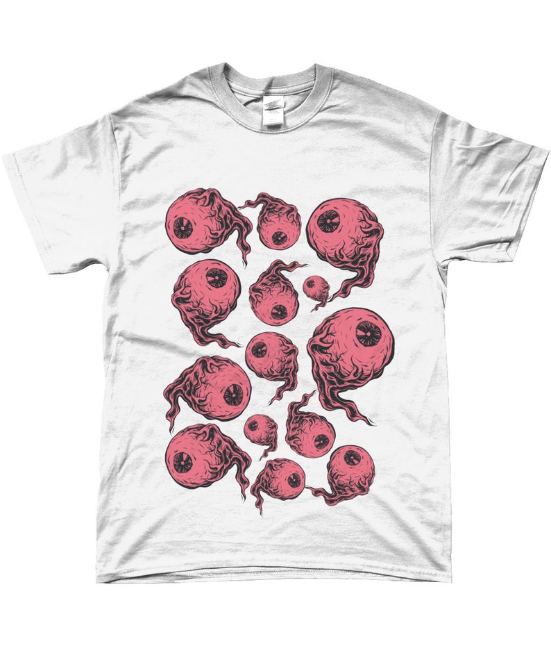 May include: White t-shirt with a graphic print of pink eyes with black outlines. The eyes are surrounded by a swirling, smoky design.