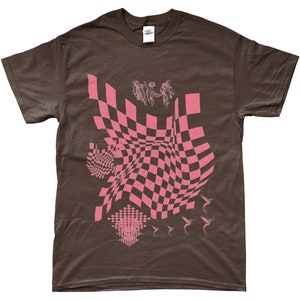 May include: A brown t-shirt featuring a pink checkered pattern, a pink graphic of three figures, and pink hummingbirds.