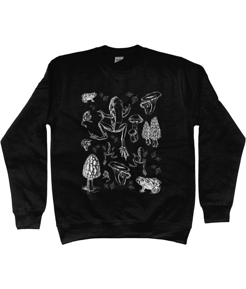 May include: Black sweatshirt with a white graphic print of a frog, mushrooms, and toadstools.
