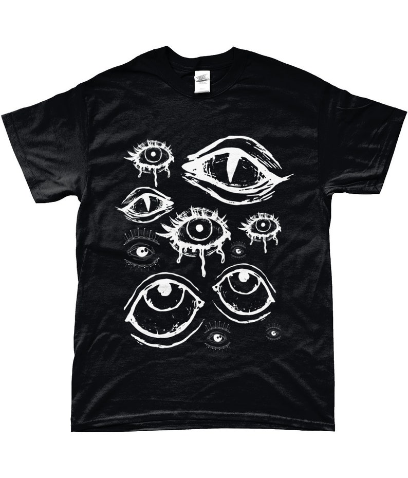 May include: Black t-shirt with a white graphic design of multiple stylized eyes. The eyes are drawn in a dripping, abstract style.