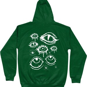 May include: A dark green hooded sweatshirt with a white graphic print of multiple stylized eyes. The eyes are drawn in a creepy, abstract style.
