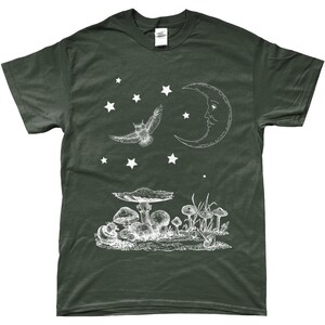 May include: A dark green t-shirt with a white graphic design of a crescent moon with a face, an owl flying, and mushrooms. There are stars scattered around the design.