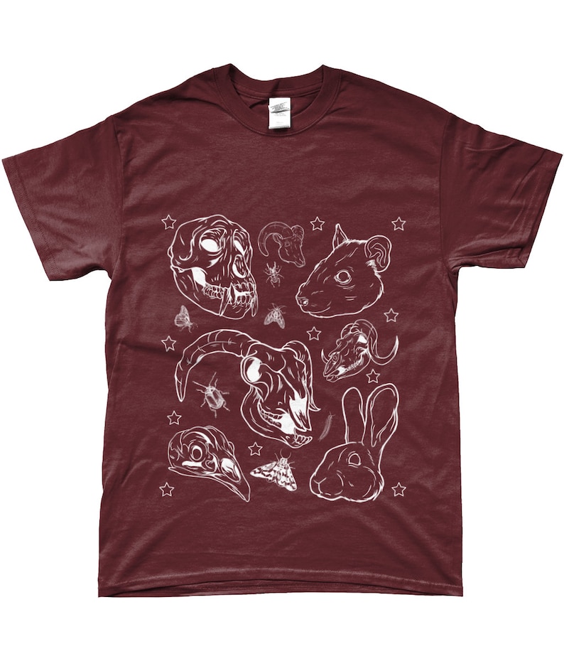 May include: A maroon t-shirt with a white design of various animal skulls, insects, and a rabbit. The design includes a monkey skull, a ram skull, a rat skull, a bird skull, and a rabbit head.