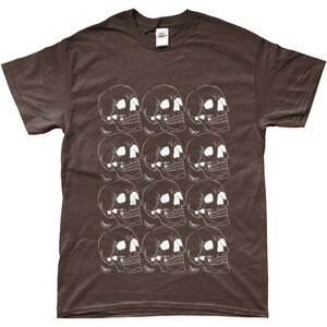 May include: A brown t-shirt with a white skull pattern. The skulls are arranged in a repeating pattern, with each skull facing a different direction.
