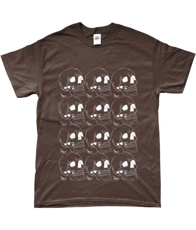 May include: A brown t-shirt with a white skull pattern. The skulls are arranged in a repeating pattern, with each skull facing a different direction.