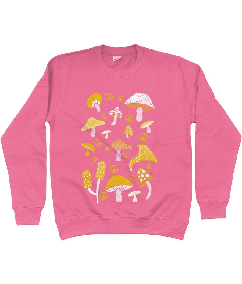 Puede incluir: Sudadera rosa con un patr&oacute;n de setas amarillas y blancas. Las setas son de varias formas y tama&ntilde;os. Hay signos de paz dispersos por todo el dise&ntilde;o.