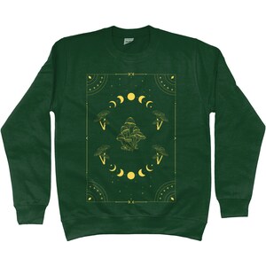 May include: A dark green sweatshirt with a yellow graphic design featuring mushrooms, moons, and stars. The design is framed by a geometric border.