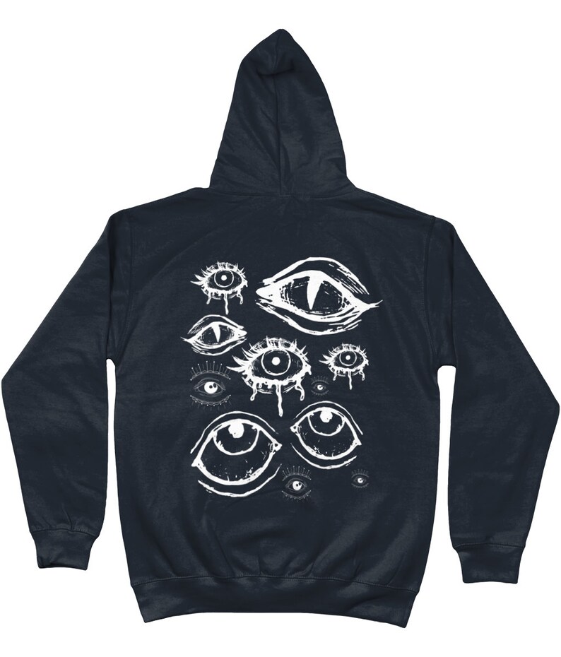 May include: A dark navy blue hooded sweatshirt with a white graphic print of multiple stylized eyes. The eyes are drawn in a variety of styles, some with tears, some with pupils, and some with a more abstract design.