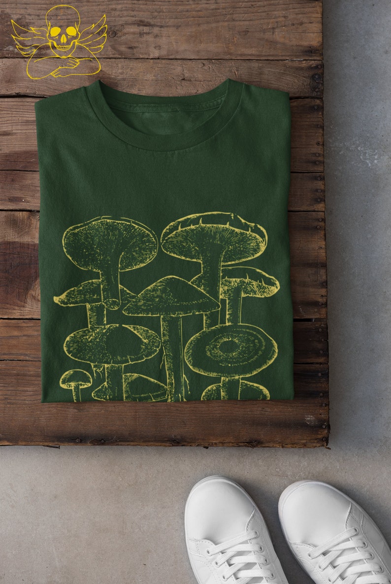 Pode incluir: Uma camiseta verde escura com uma estampa gr&aacute;fica amarela de um grupo de cogumelos.
