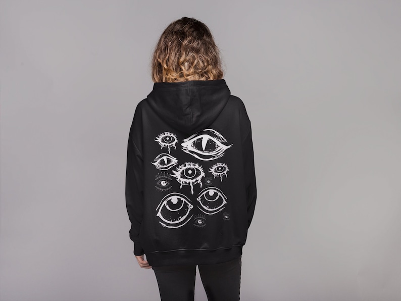 May include: Black hoodie with a white graphic print of multiple eyes on the back.