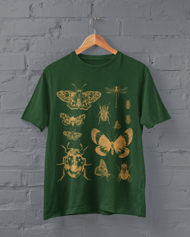 May include: A dark green t-shirt with a vintage-style print of various insects and butterflies in a light brown color. The insects include a dragonfly, beetles, and moths.
