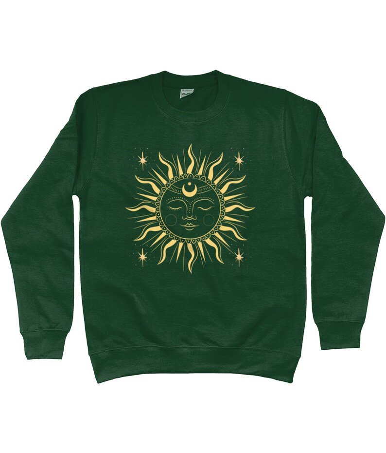 May include: A dark green sweatshirt with a gold sun and moon design. The sun has a face and is surrounded by stars.