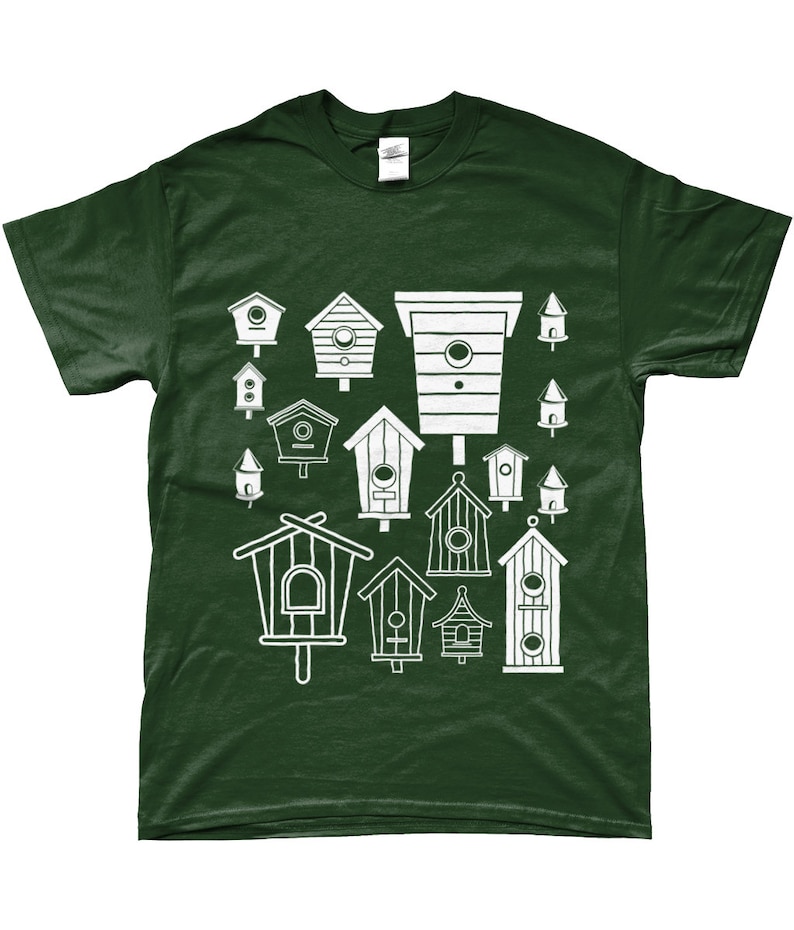 May include: A dark green t-shirt featuring a white design of various birdhouses. The birdhouses are all different shapes and sizes, and some have small holes for birds to enter.