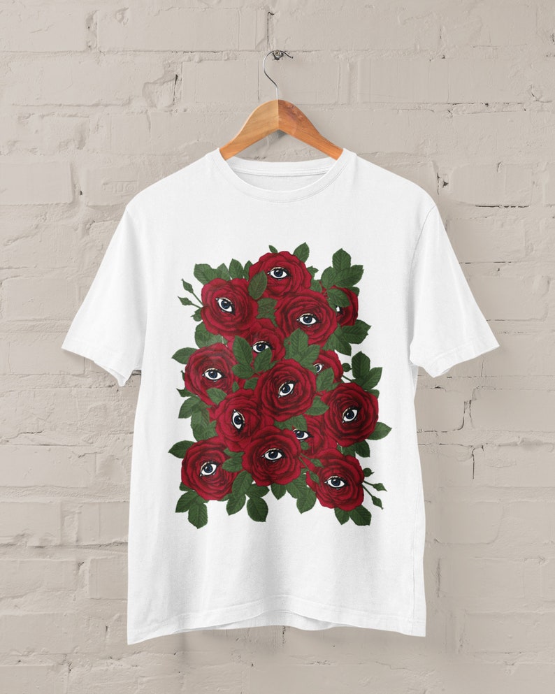 May include: White t-shirt with a graphic print of red roses with eyes in the center of each rose.