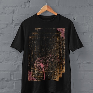 May include: Black t-shirt featuring a dandelion graphic print in pink and gold on a distressed background.