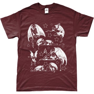 May include: A maroon t-shirt with a white graphic print of multiple winged figures with stars. The figures are in various poses, some flying, some sitting, and some lying down.