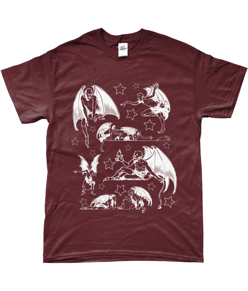 May include: A maroon t-shirt with a white graphic print of multiple winged figures with stars. The figures are in various poses, some flying, some sitting, and some lying down.