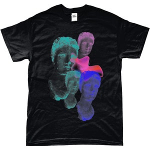 May include: Black t-shirt with a graphic print of multiple colorful, abstract, and layered faces. The faces are reminiscent of ancient Greek or Roman sculptures.
