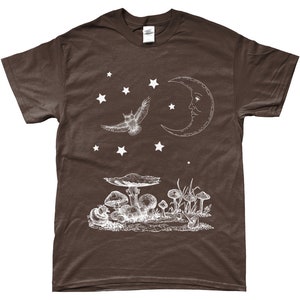 May include: A brown t-shirt with a white graphic design of an owl flying under a crescent moon with a face. There are stars and mushrooms in the design.