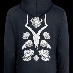 May include: A dark blue hoodie with a white design of animal skulls. The design features a deer skull in the center with two antelope skulls on either side. There are also two bird skulls and two monkey skulls.