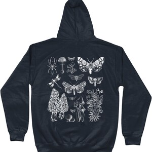May include: A dark blue hooded sweatshirt with a white print of various insects, mushrooms, and plants. The print includes a spider, dragonfly, butterflies, and mushrooms.