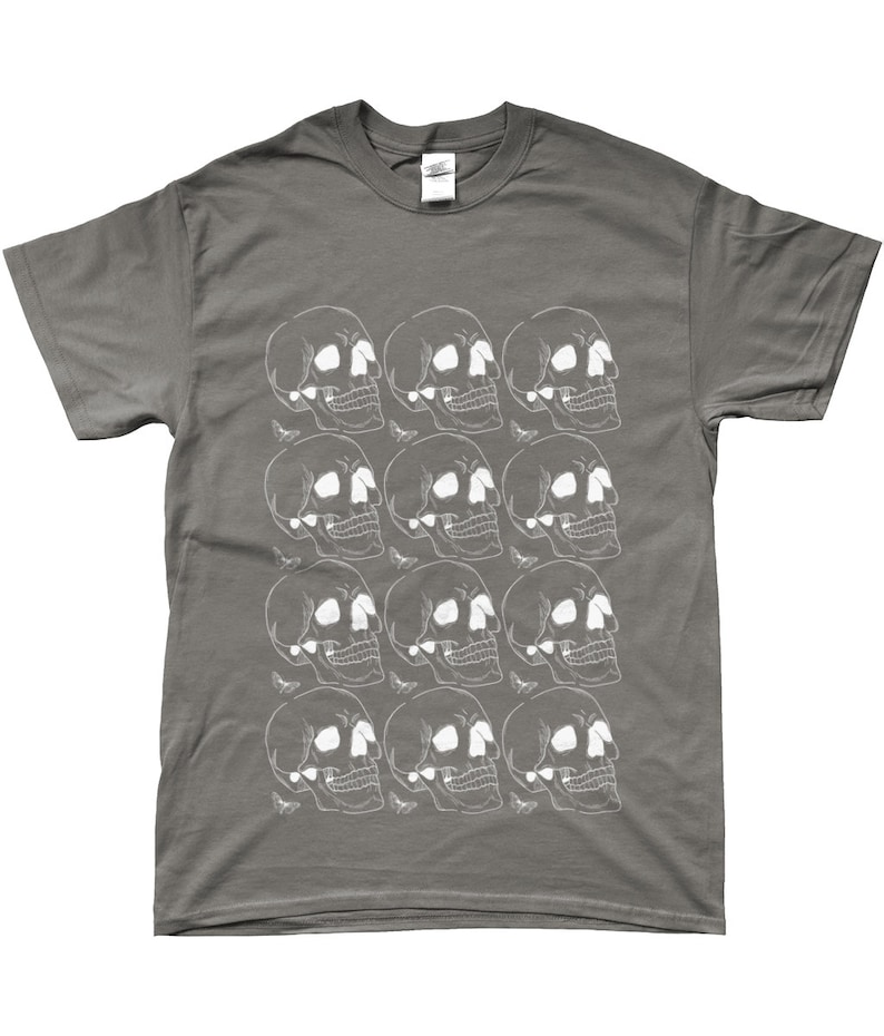 May include: A charcoal gray t-shirt with a white skull pattern. The skulls are arranged in a repeating pattern across the front of the shirt.