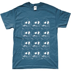 May include: A teal blue t-shirt with a white graphic print of a repeating pattern of skulls.