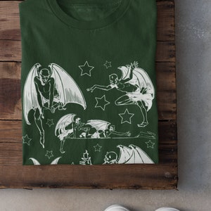 May include: A dark green t-shirt with a white print of multiple winged figures and stars.