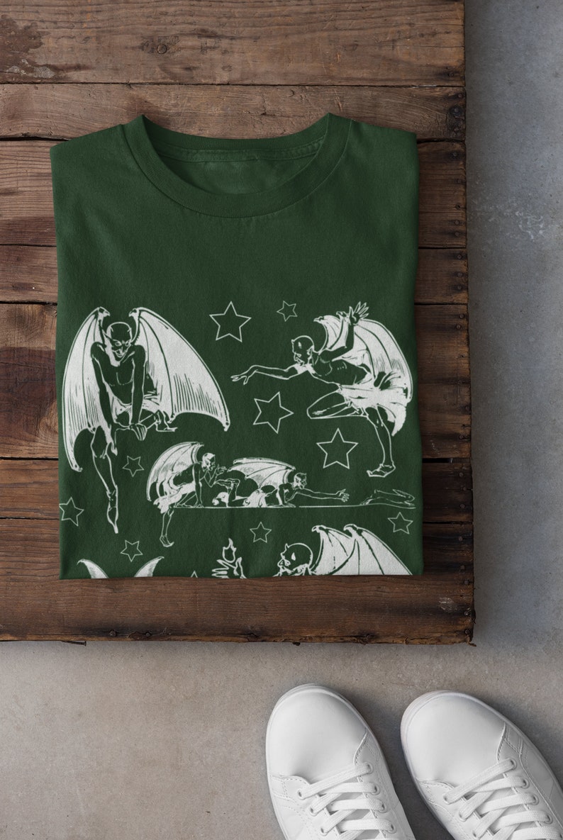 May include: A dark green t-shirt with a white print of multiple winged figures and stars.