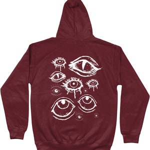 May include: Burgundy hooded sweatshirt with a white graphic print of multiple stylized eyes.