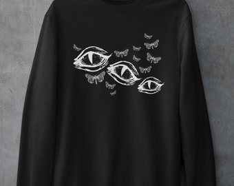 May include: Black sweatshirt with a white graphic print of three eyes and a cluster of butterflies.